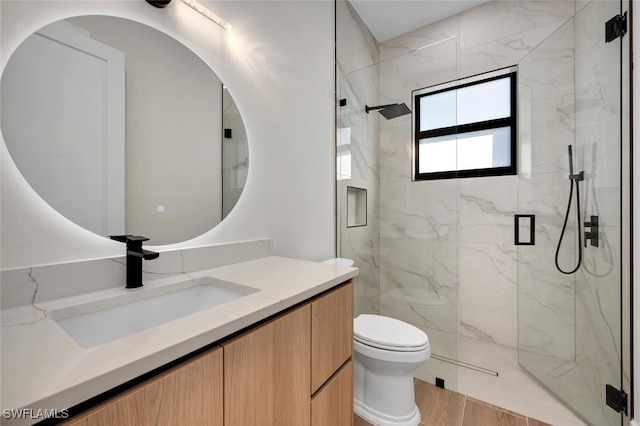 full bath featuring a marble finish shower, vanity, toilet, and wood finished floors