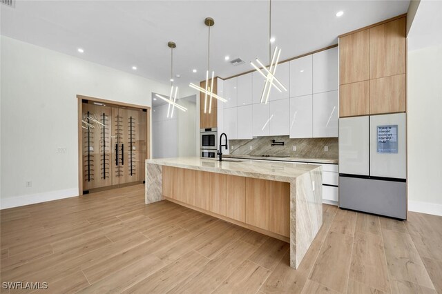 kitchen featuring freestanding refrigerator, backsplash, and modern cabinets