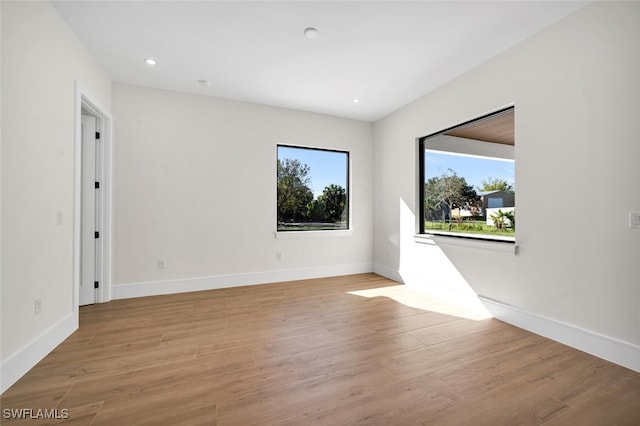 spare room featuring light wood-style floors and baseboards