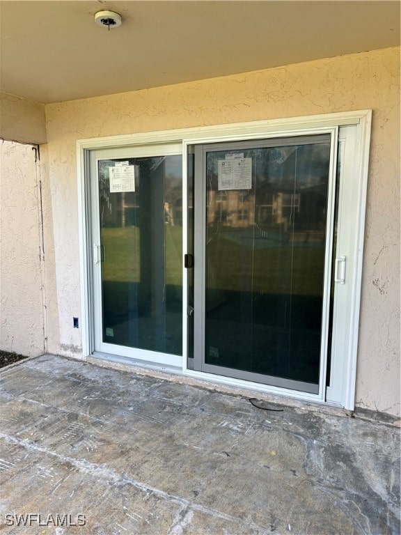 view of exterior entry with a patio area