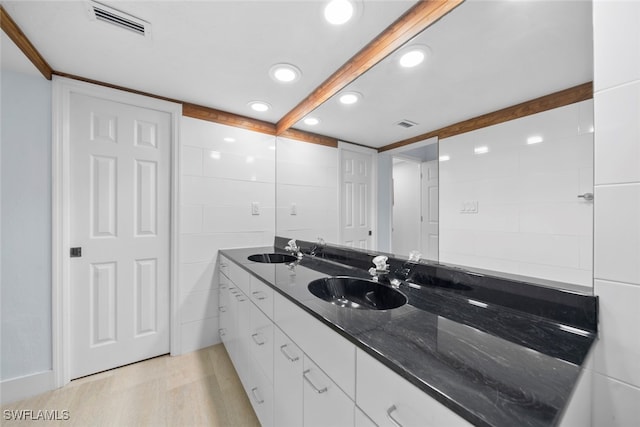 bathroom with beamed ceiling, vanity, and hardwood / wood-style flooring