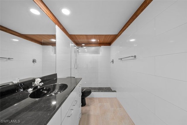 bathroom featuring toilet, wood ceiling, tile walls, a tile shower, and vanity