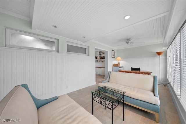 living room featuring crown molding, built in features, and ceiling fan