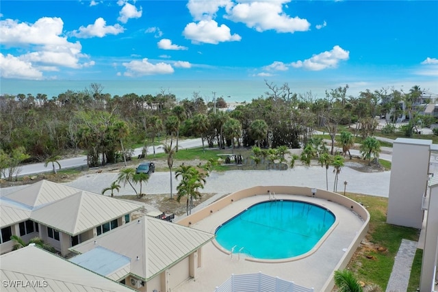 view of pool with a patio and a water view