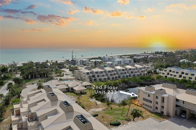 aerial view at dusk featuring a water view