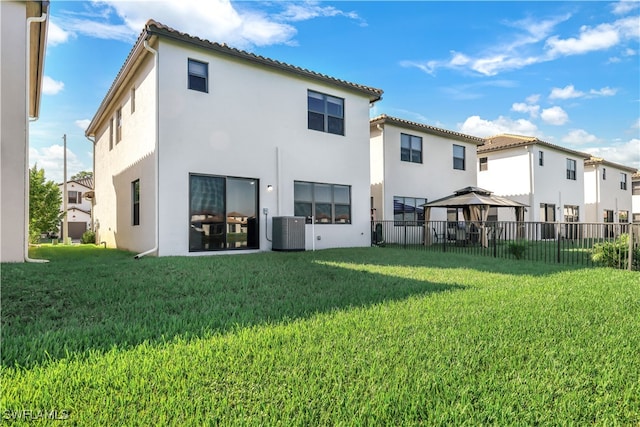 back of property with a gazebo, central AC, and a lawn