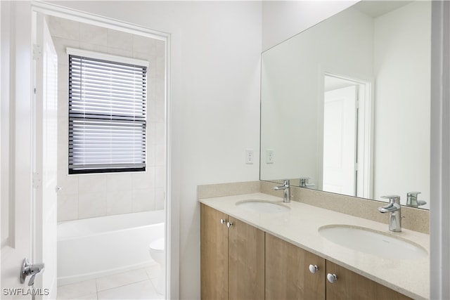 bathroom with tile patterned flooring, vanity, a bathtub, and toilet