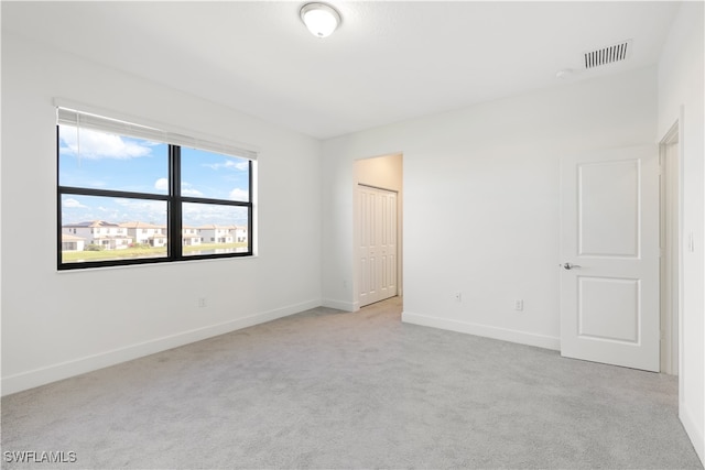 unfurnished room featuring light carpet