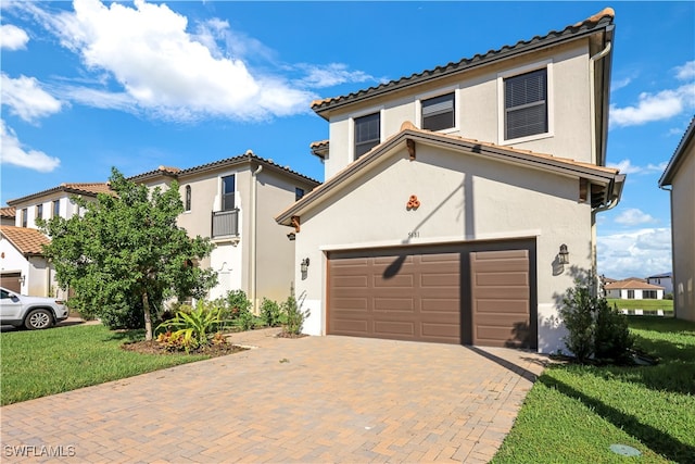 mediterranean / spanish house featuring a garage and a front yard