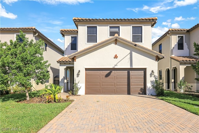 mediterranean / spanish house with a garage and a front lawn