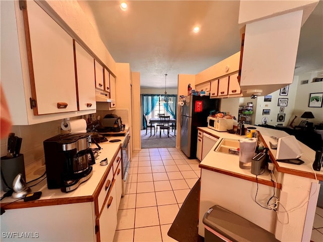 kitchen with light tile patterned floors, white appliances, white cabinetry, and pendant lighting