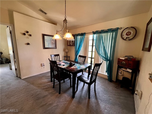 dining room with a notable chandelier, dark carpet, and vaulted ceiling