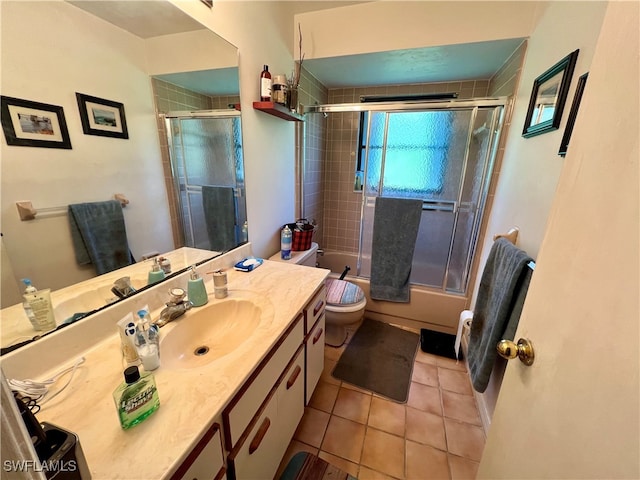 full bathroom with shower / bath combination with glass door, tile patterned flooring, vanity, and toilet