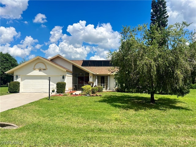 view of front of property with a front lawn, a garage, and solar panels