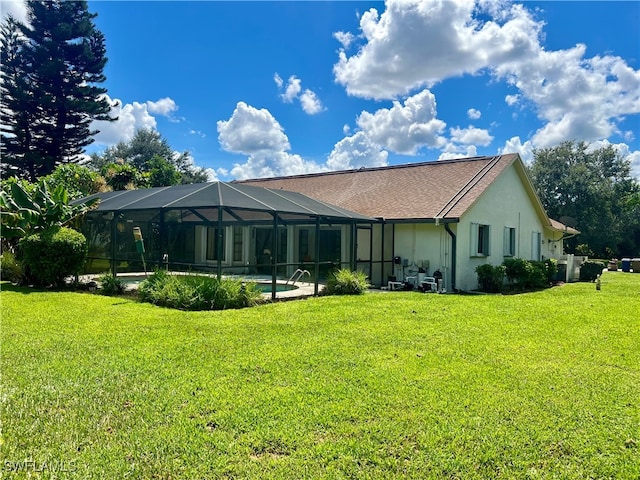 rear view of property with glass enclosure and a yard