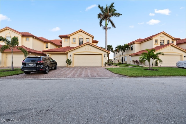 mediterranean / spanish-style home featuring a front yard and a garage