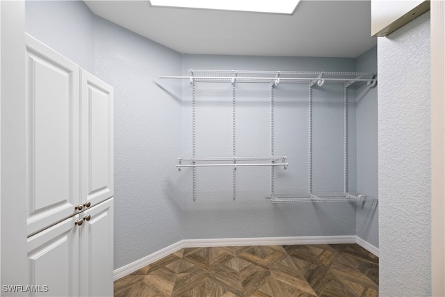 walk in closet featuring dark parquet flooring