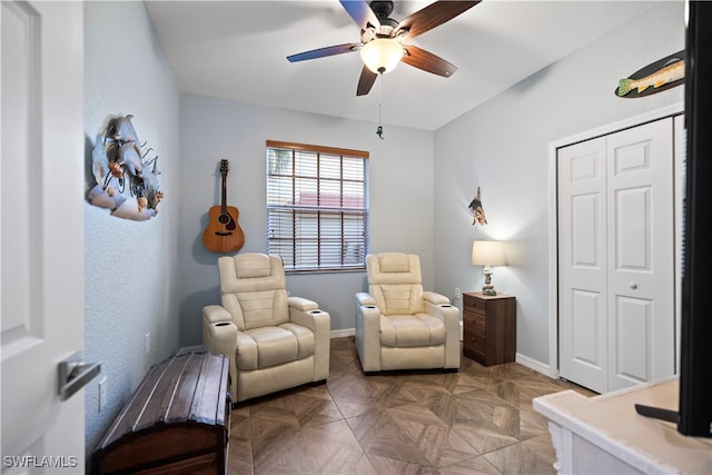 sitting room featuring parquet flooring and ceiling fan