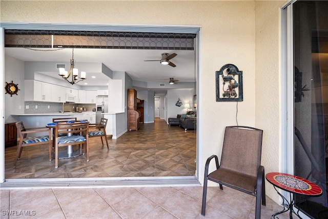 dining room with light parquet floors and ceiling fan with notable chandelier