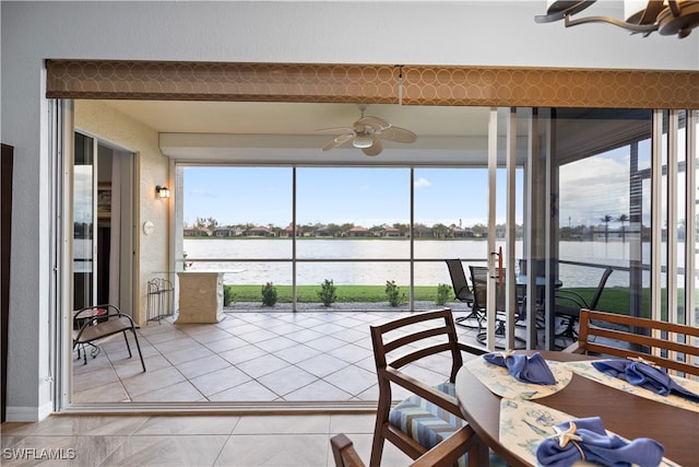 sunroom featuring a water view, ceiling fan, and a healthy amount of sunlight