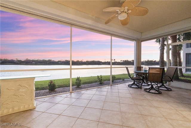 sunroom / solarium featuring a water view and ceiling fan