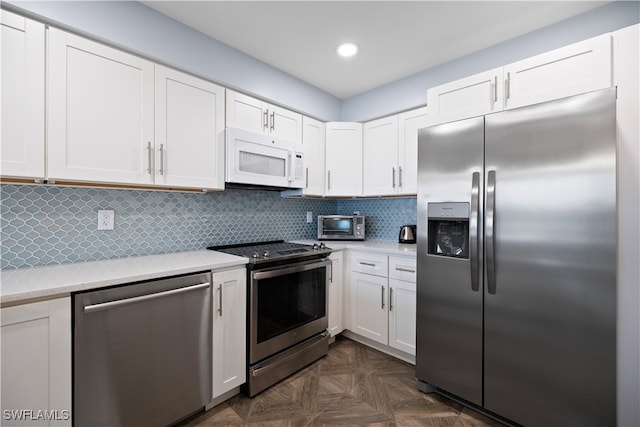 kitchen featuring backsplash, white cabinetry, dark parquet floors, and stainless steel appliances