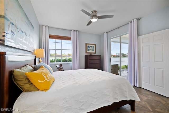 bedroom featuring access to exterior, dark parquet floors, and ceiling fan