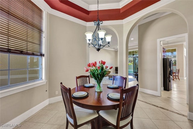 dining area featuring light tile patterned floors, a chandelier, arched walkways, and crown molding