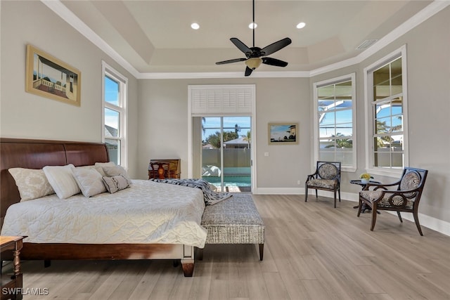 bedroom with light wood-type flooring, a raised ceiling, baseboards, and access to outside