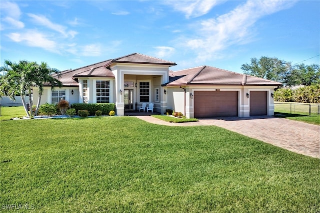 view of front of property with a front yard and a garage