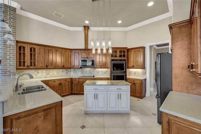 kitchen featuring brown cabinets, appliances with stainless steel finishes, glass insert cabinets, and a sink