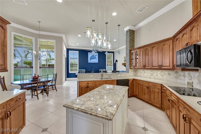 kitchen featuring sink, crown molding, decorative light fixtures, a kitchen island, and black appliances