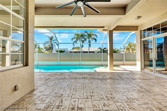 view of pool with glass enclosure, a patio area, a fenced in pool, and ceiling fan