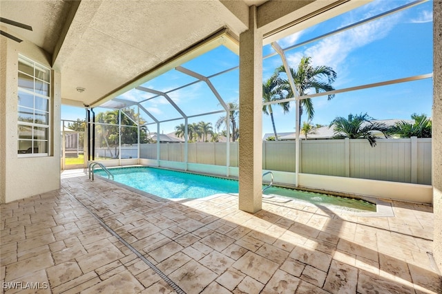 view of swimming pool featuring a patio and glass enclosure