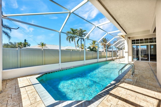 view of pool featuring glass enclosure, a patio area, fence private yard, and a fenced in pool