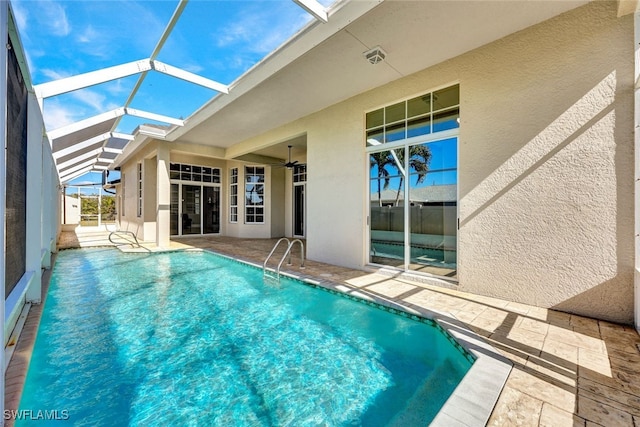 outdoor pool featuring a patio area, glass enclosure, and ceiling fan