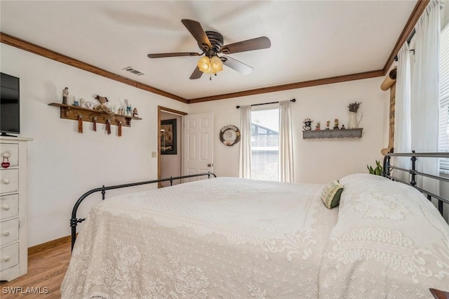 bedroom featuring light hardwood / wood-style flooring, ornamental molding, and ceiling fan