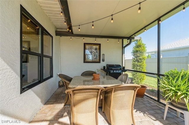 sunroom / solarium featuring rail lighting