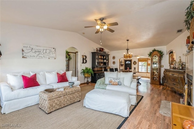 living room featuring hardwood / wood-style flooring, vaulted ceiling, and ceiling fan with notable chandelier