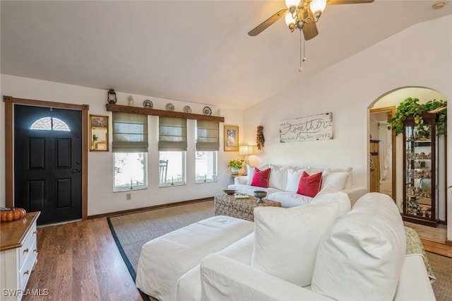 living room with dark wood-type flooring, ceiling fan, and vaulted ceiling