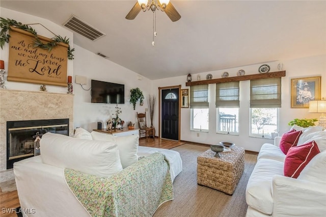 living room featuring wood-type flooring, a high end fireplace, ceiling fan, and vaulted ceiling