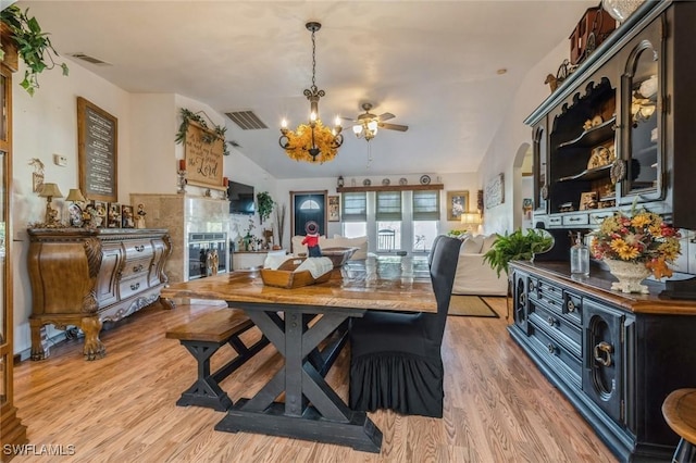 dining room with lofted ceiling, a notable chandelier, and light wood-type flooring