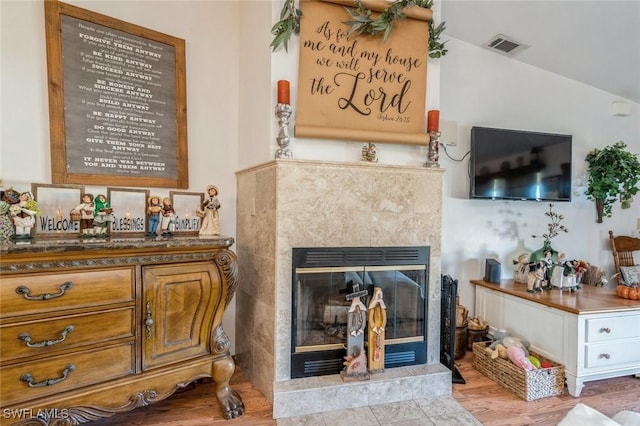 room details featuring hardwood / wood-style flooring and a tile fireplace