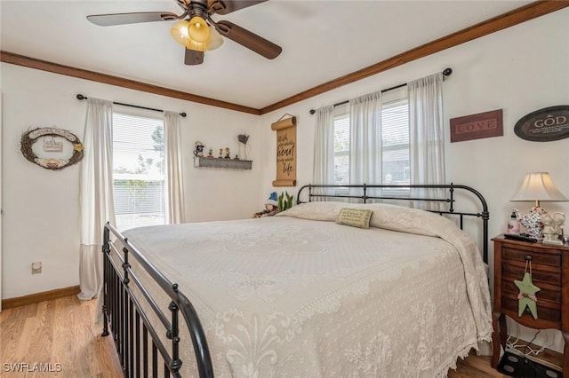 bedroom with ceiling fan, ornamental molding, light hardwood / wood-style floors, and multiple windows