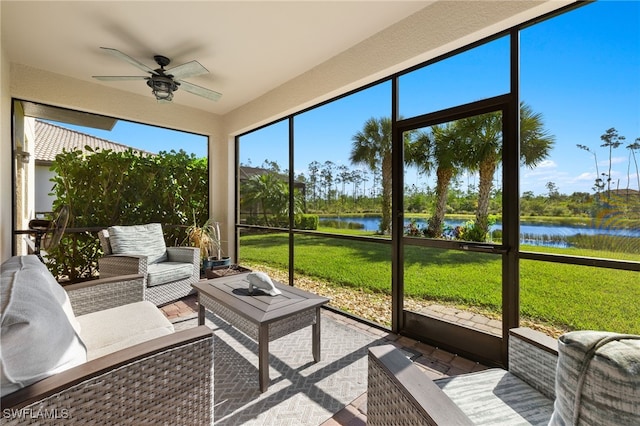 sunroom / solarium with ceiling fan and a water view