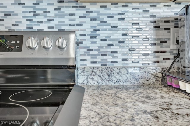 room details with light stone countertops, electric range, and decorative backsplash