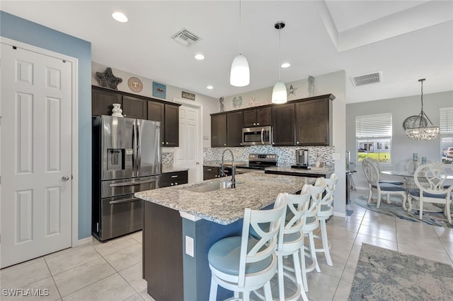 kitchen with dark brown cabinetry, sink, decorative light fixtures, and appliances with stainless steel finishes