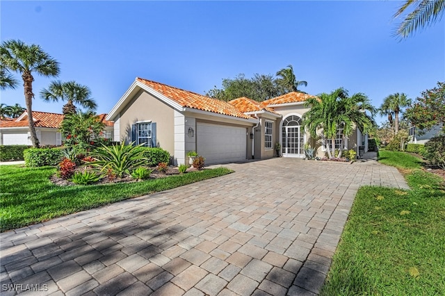 mediterranean / spanish-style home featuring a garage and a front lawn