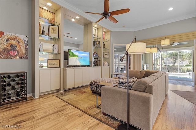 living room featuring light hardwood / wood-style flooring, ceiling fan, and crown molding