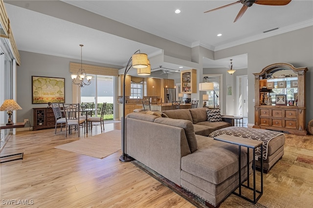 living room featuring ceiling fan with notable chandelier, light hardwood / wood-style floors, and ornamental molding